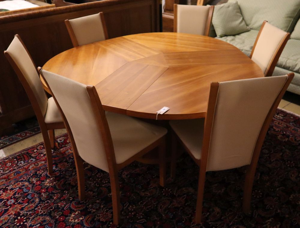 Skovby, Denmark, a patent cherrywood revolving expanding circular table with three integral leaves, width 145cm, height 73cm and a set